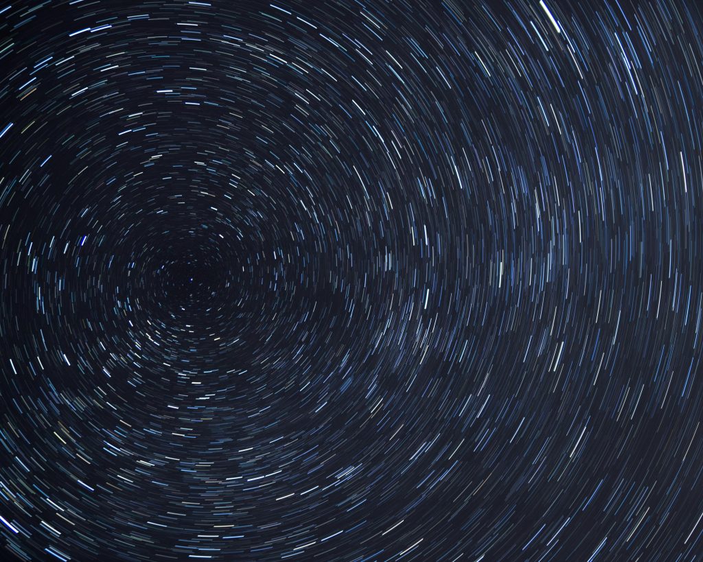 Dazzling star trails creating a spiral effect in the clear night sky.